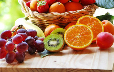 half orange, sliced kiwi, other fruits in the basket