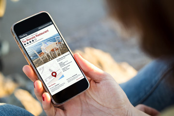 woman sitting in the street holding her smartphone looking for a