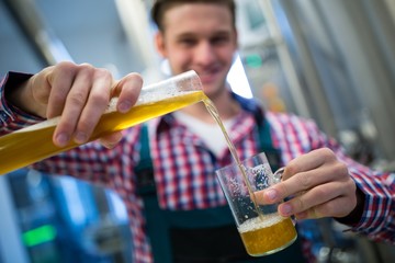 Brewer pouring beer in glass