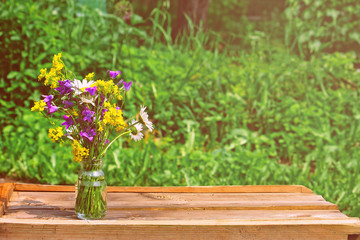 Fototapeta na wymiar Summer bouquet wild flowers in glass bottle