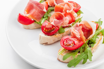 Jamon. Slices of Bread with Spanish Serrano Ham Served as Tapas. Cured ham, spanish appetizer. Prosciutto isolated on white background