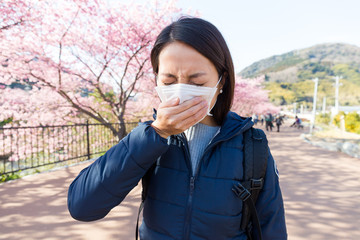 Woman suffer cough with sakura tree