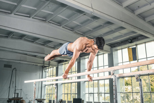 Male Gymnast Performing Handstand On Parallel Bars