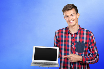 Young handsome businessman holding laptop