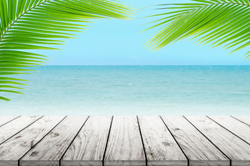 old wood table top on blurred beach background with coconut leaf
