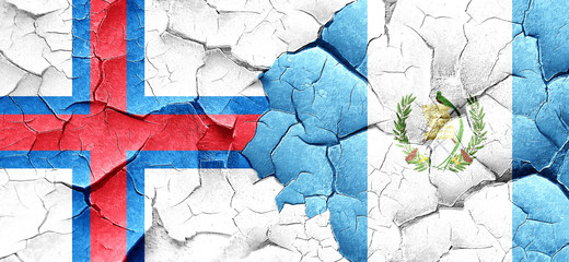 faroe islands flag with Guatemala flag on a grunge cracked wall