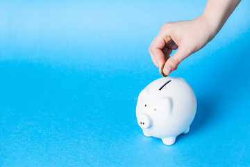 Inserting a coin into a piggy bank