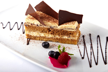 Cake with custard and summer berries on a white background