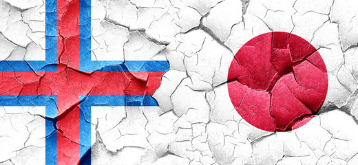 faroe islands flag with Japan flag on a grunge cracked wall