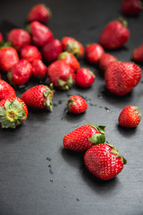 angle view with a side, fresh strawberry harvest nicely scattered