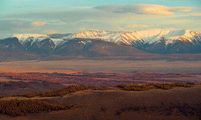 Долина на фоне заснеженных хребтов гор