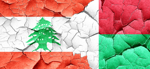 Lebanon flag with Madagascar flag on a grunge cracked wall
