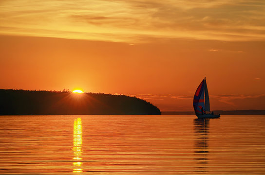 a yacht with sails in the sunset