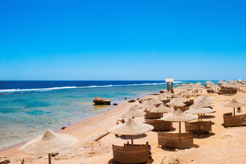Beach umbrellas and deckchair on the tropical beach. Egypt.