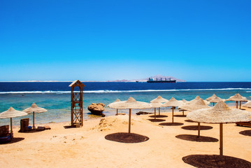 Beach umbrellas and deckchair on the tropical beach. Egypt.