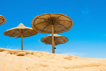 Beach umbrellas and deckchair on the tropical beach. Egypt.