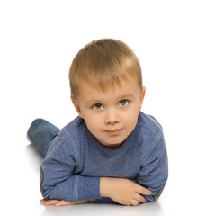 Beautiful little boy on the floor and looks into the camera - Isolated on white background