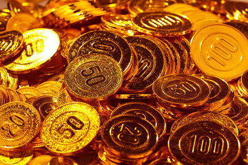 Golden coins piled in a heap of background