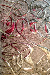 Close up of textured glass pattern with colored reflections.