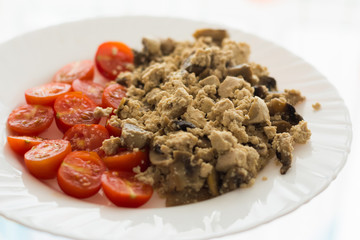 Healthy vegan omelette cooked for breakfast made of tofu, mushrooms and tomatoes