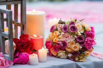 Beautiful, delicate bridal bouquet among decoration with candles and fresh flowers