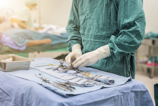 scrub nurse preparing surgical instruments for operation