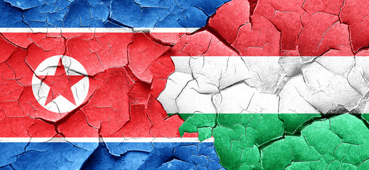 North Korea flag with Hungary flag on a grunge cracked wall