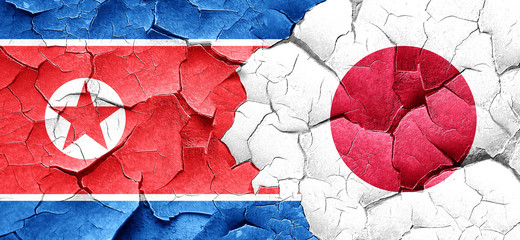 North Korea flag with Japan flag on a grunge cracked wall