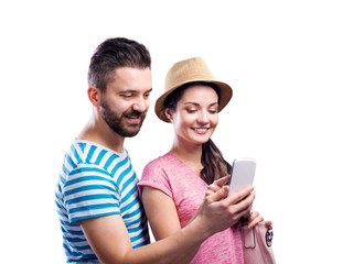 Couple in summer clothes with smartphone, taking selfie