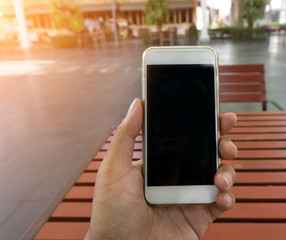 Man's hand shows mobile smartphone in vertical position, blurred