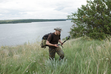 Hiker walking in the field and filming on action camera