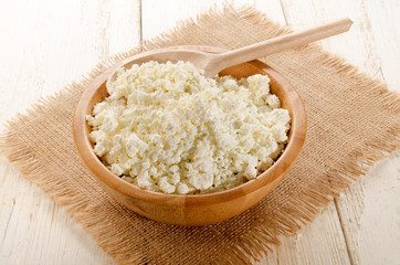 home made cottage cheese with wooden spoon in a wooden bowl