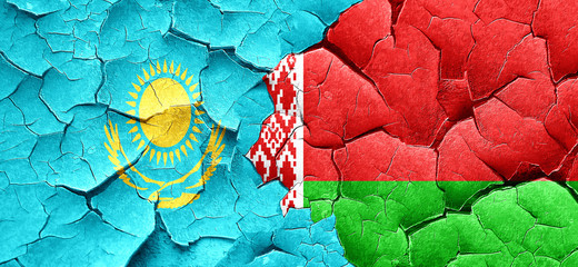 Kazakhstan flag with Belarus flag on a grunge cracked wall