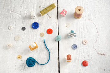 Sewing tools on white wood background