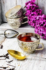 Still life with tea and branch of lilac