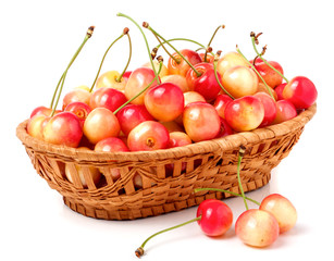 yellow cherries in a wicker basket isolated on white background