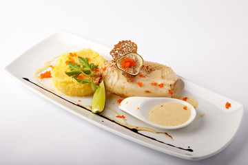 Baked squid with mashed potato and sauce on a white background