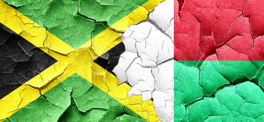 Jamaica flag with Madagascar flag on a grunge cracked wall