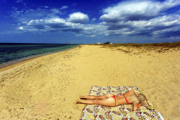 The girl sunbathes on the beach