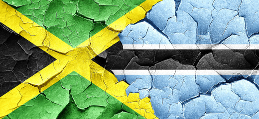Jamaica flag with Botswana flag on a grunge cracked wall