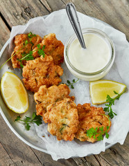 Chicken cutlets with lemon and herbs on a plate on a wooden background. top view
