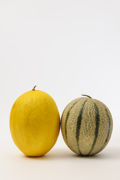 Frontal view of a Cantaloupe melon and a Canary Melon on white background