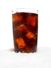 Glass of cola with ice cubes on snow on white