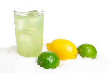 Glass of lime juice with ice cubes,limes,lemon on snow on white