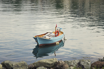 Naklejka premium Lonely traditional turkish fishing boat on sea water