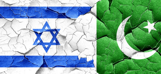 Israel flag with Pakistan flag on a grunge cracked wall