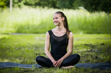 Naklejka na ściany i meble Portrait of sporty woman doing stretching exercises in park before training. Female athlete preparing for jogging outdoors. Sport active lifestyle concept. Full length