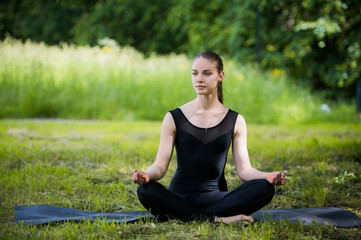 Fototapeta na wymiar Young girl doing yoga in the park