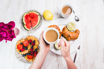 Schön gedeckter Tisch mit frischen Waffeln und Kaffee
