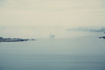 A boat and fisherman on a quiet sea. Retro effect